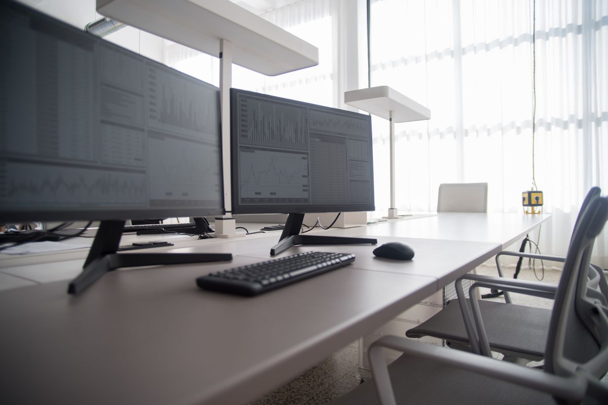 A large monitor next to a smaller one on desks